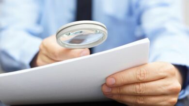 Businessman-looking-through-a-magnifying-glass-to-contract-cm