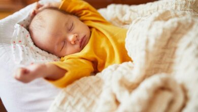 Newborn-baby-sleeping-under-knitted-blanket-cm