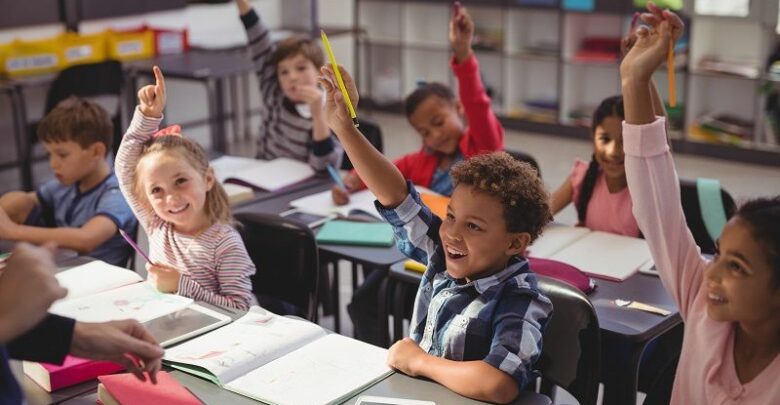 Schoolkids-raising-their-hands-in-classroom-cm