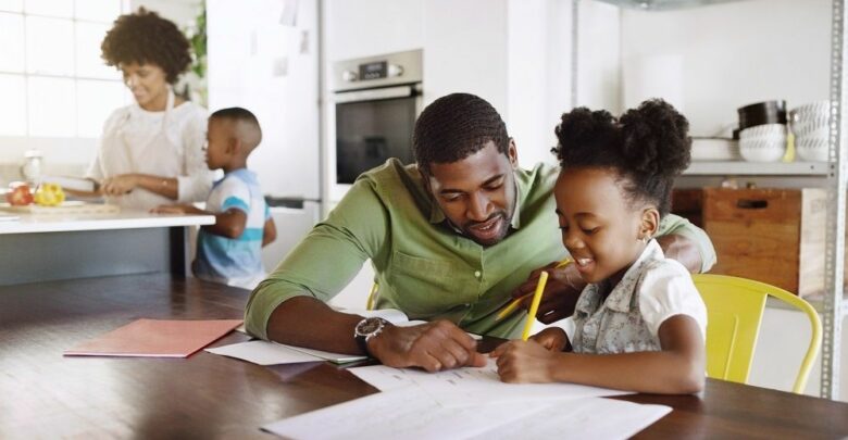 African-American-father-homeschooling-daughter-at-kitchen-table