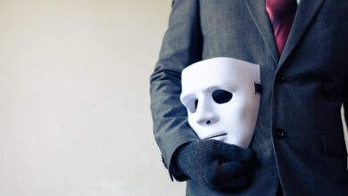 Man in a Suit With a Mask by His SIde