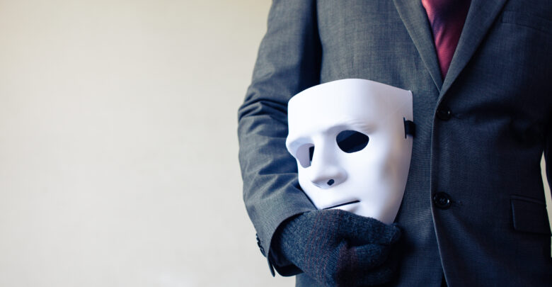 Man in a Suit With a Mask by His SIde