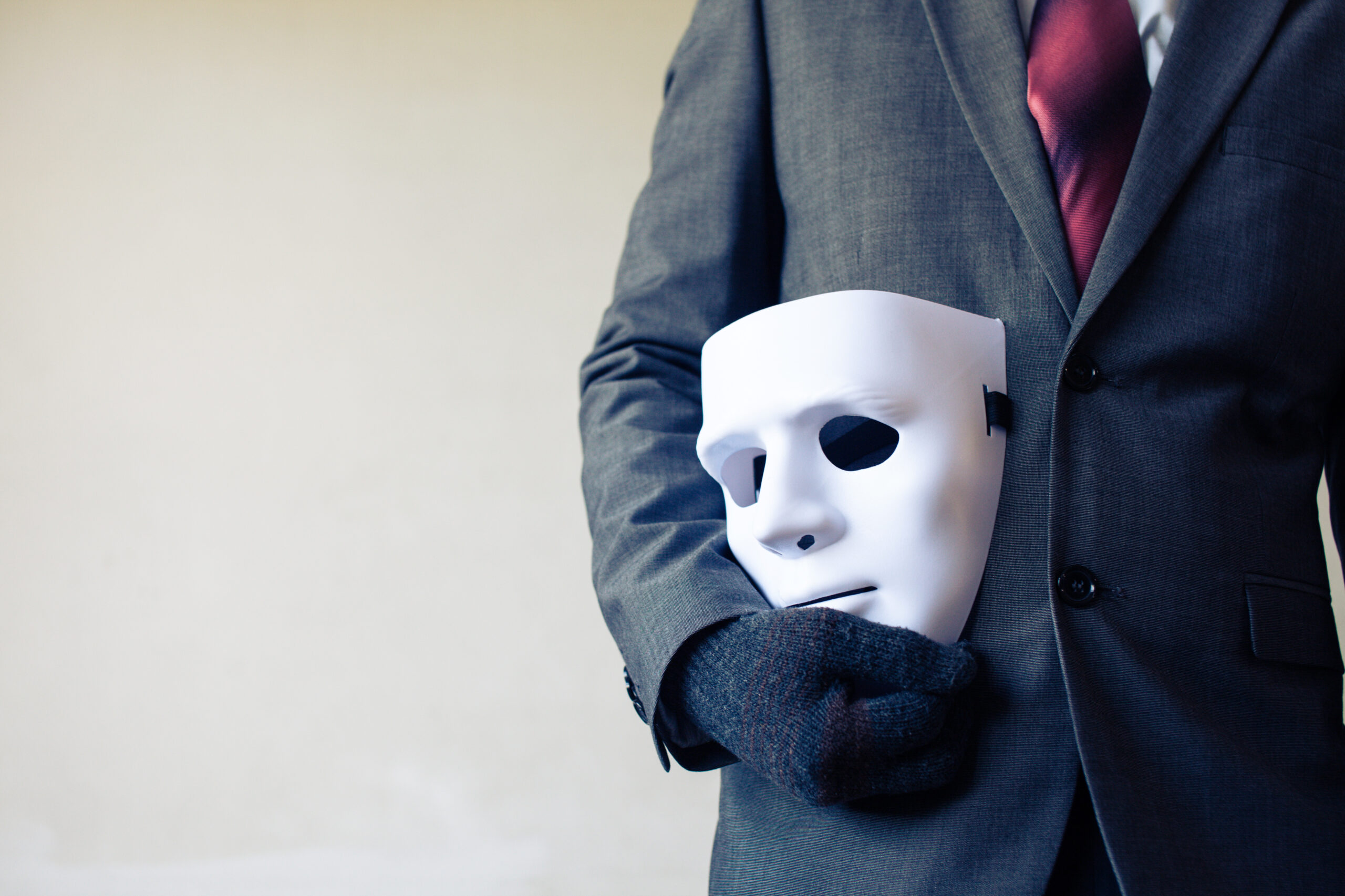 Man in a Suit With a Mask by His SIde